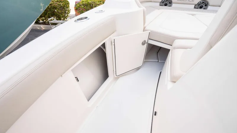 Slide: The Image of 2025 Solace 28 HCS boat interior with open storage compartment and cushioned seating. - 25