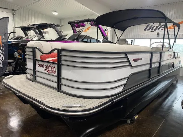 Slide: The Image of 2025 SunCatcher Elite 326 SS pontoon boat displayed in showroom. - 2