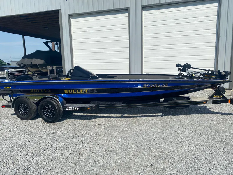 Slide: The Image of 2013 Bullet 21XRD boat on trailer, parked outside a garage. - 13