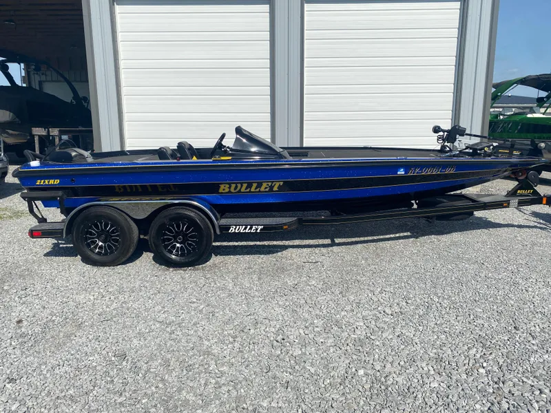 Slide: The Image of 2013 Bullet 21XRD boat on trailer, parked outdoors, side view. - 14