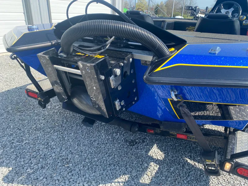 Slide: The Image of 2013 Bullet 21XRD boat on trailer, blue with yellow accents, parked on gravel. - 6