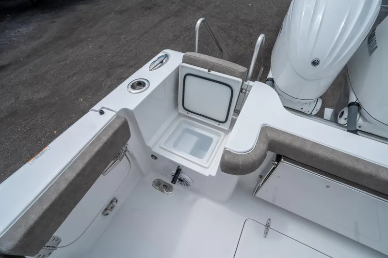 Slide: The Image of 2025 Sea Hunt Gamefish 28 CB boat interior with open storage compartment and twin engines. - 16