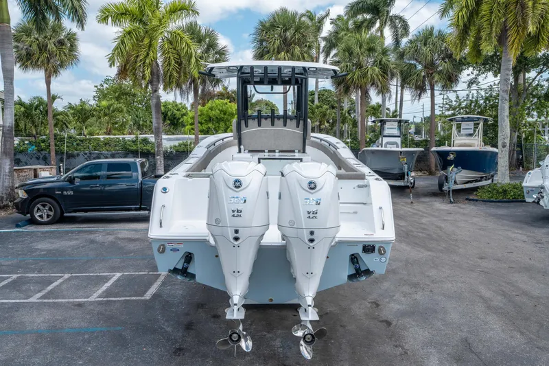 Slide: The Image of 2025 Sea Hunt Gamefish 28 CB boat with dual engines, parked outdoors among palm trees. - 3