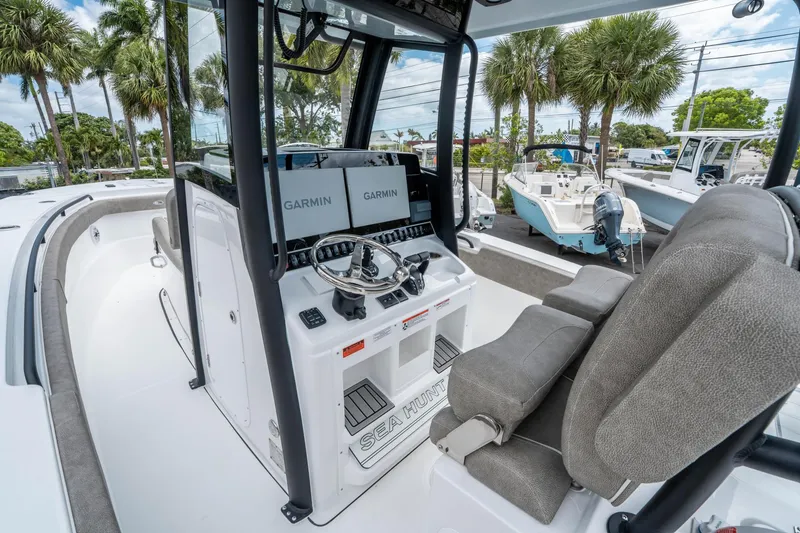 Slide: The Image of 2025 Sea Hunt Gamefish 28 CB boat interior with Garmin displays and steering wheel. - 17