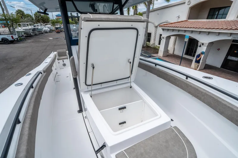 Slide: The Image of 2025 Sea Hunt Gamefish 28 CB boat with open storage compartment, docked at marina. - 27