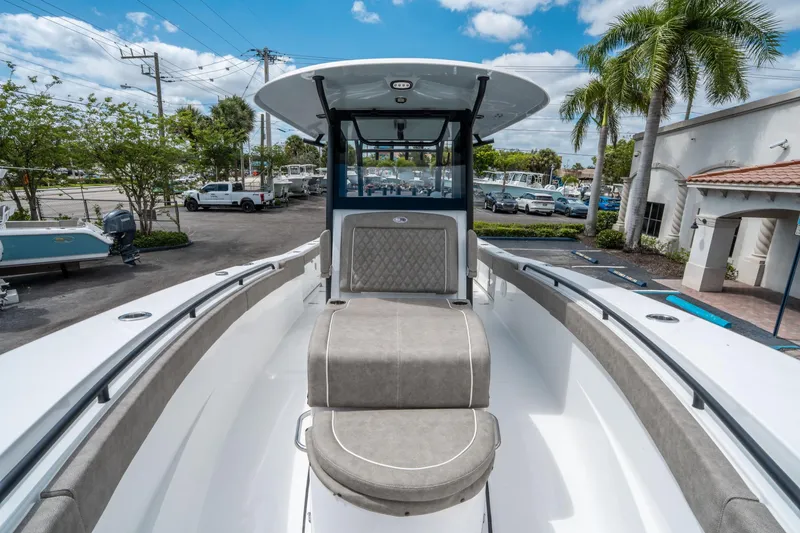 Slide: The Image of 2025 Sea Hunt Gamefish 28 CB boat with cushioned seating, docked under a clear sky. - 30