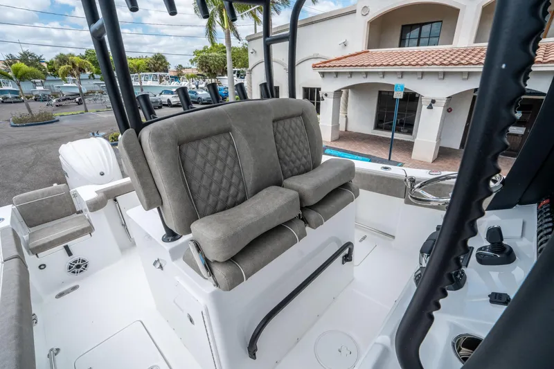 Slide: The Image of 2025 Sea Hunt Gamefish 28 CB boat interior with cushioned seating and control panel. - 21