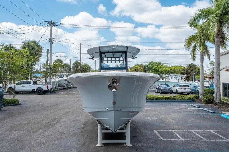 Slide: The Image of 2025 Sea Hunt Gamefish 28 CB boat displayed in a parking lot with palm trees. - 7