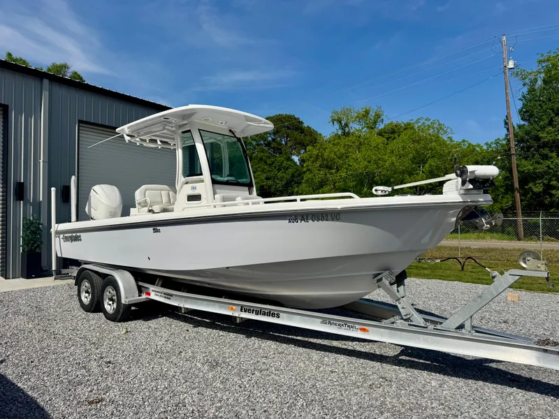 Slide: The Image of 2019 Everglades 253CC boat on trailer, parked outside a metal building. - 1