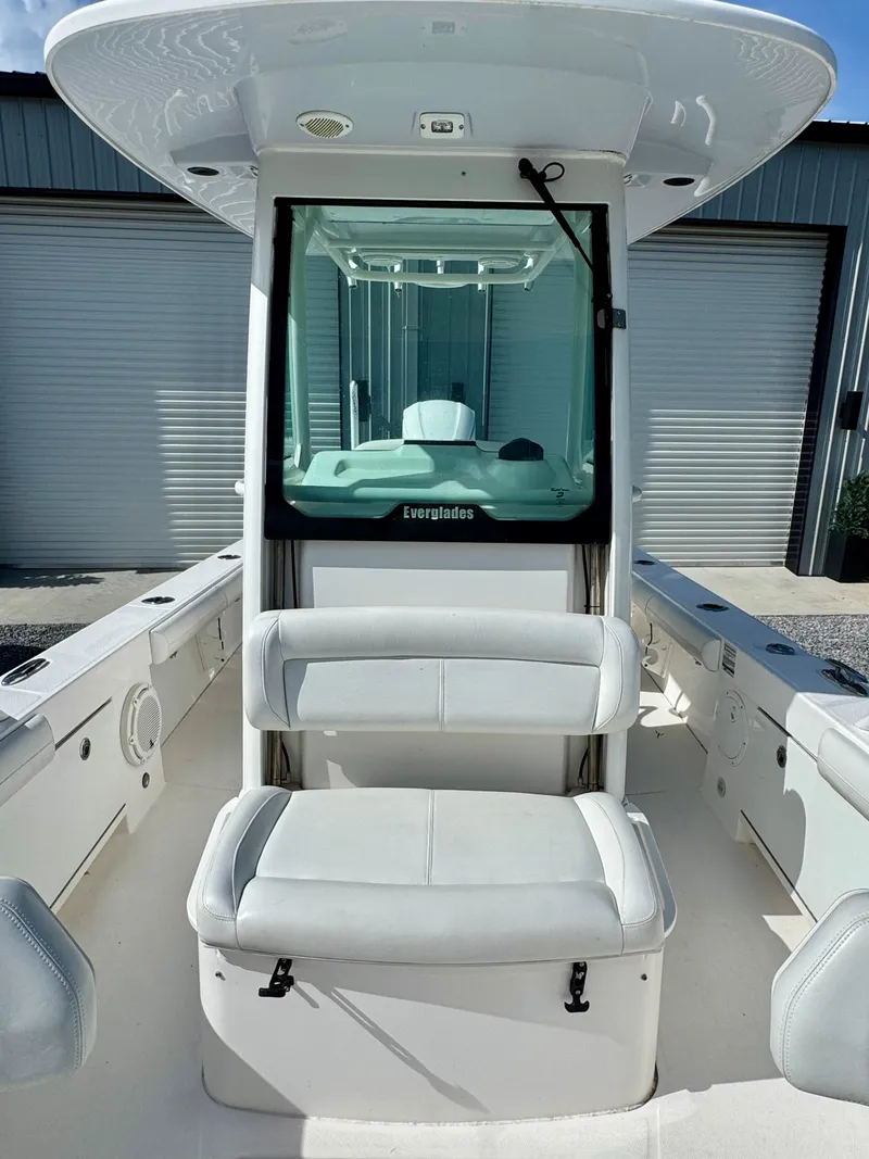 Slide: The Image of 2019 Everglades 253CC boat interior with seating and console, in a storage area. - 13