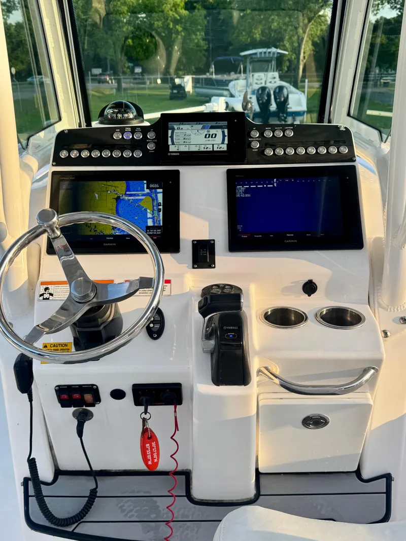 Slide: The Image of 2019 Everglades 253CC boat dashboard with navigation screens and steering wheel. - 15