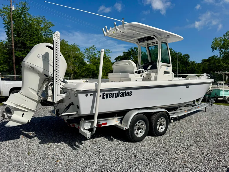 Slide: The Image of 2019 Everglades 253CC boat on trailer, parked outdoors on gravel. - 2