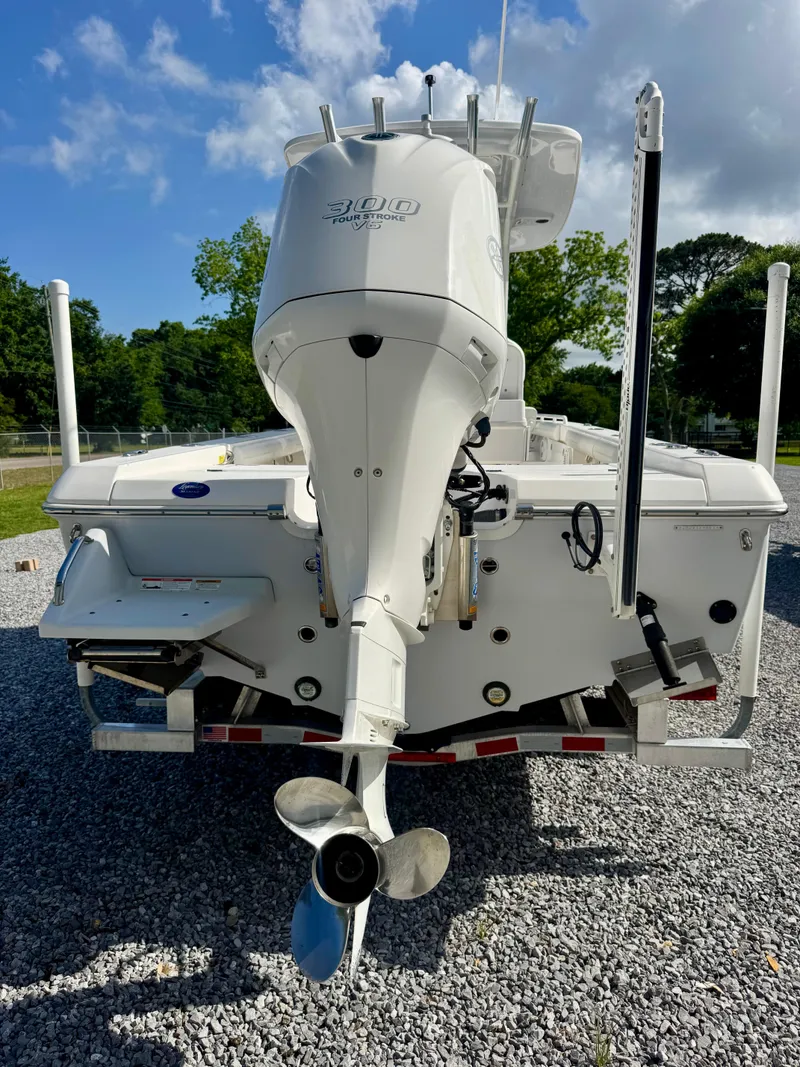 Slide: The Image of 2019 Everglades 253CC boat rear view with outboard motor on gravel. - 4