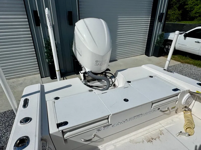 Slide: The Image of 2019 Everglades 253CC boat with outboard motor, parked near storage units. - 7