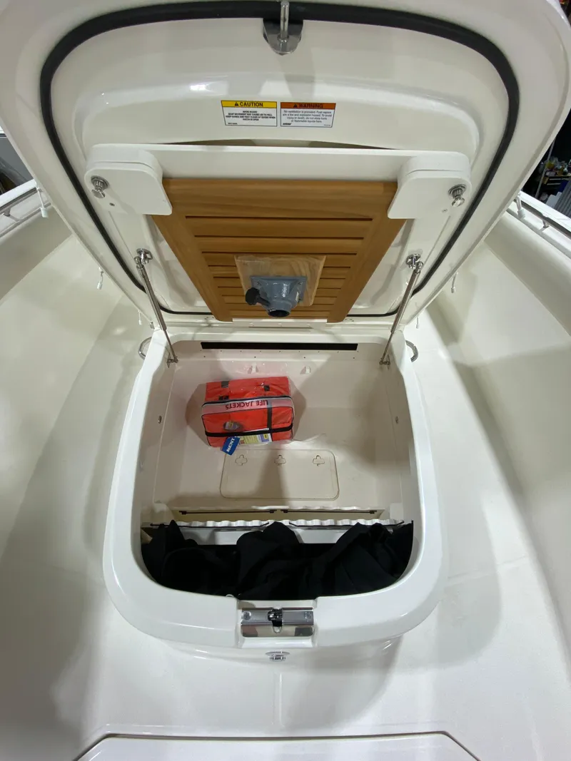 Slide: The Image of 2023 Boston Whaler 330 Outrage storage compartment with safety equipment. - 14