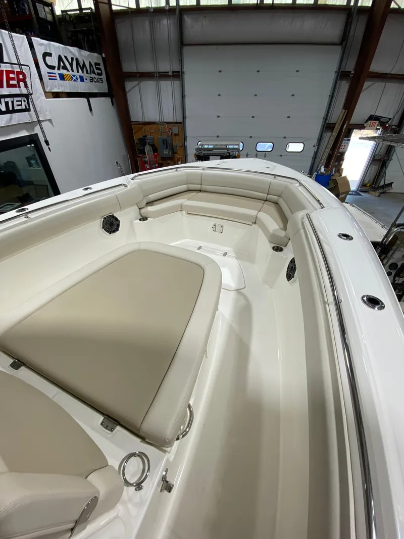 Slide: The Image of 2023 Boston Whaler 330 Outrage boat interior with beige seating in a showroom. - 17