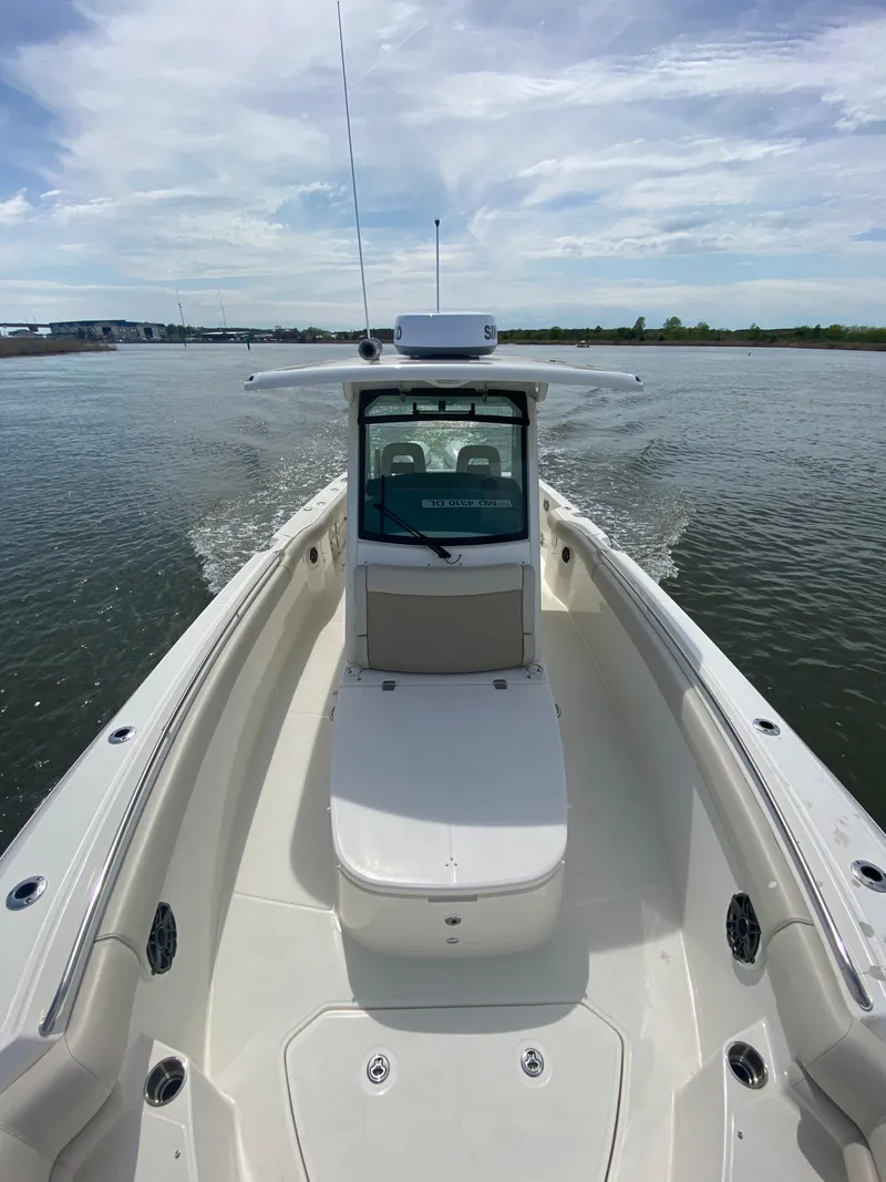 Slide: The Image of 2023 Boston Whaler 330 Outrage cruising on calm waters under a partly cloudy sky. - 31