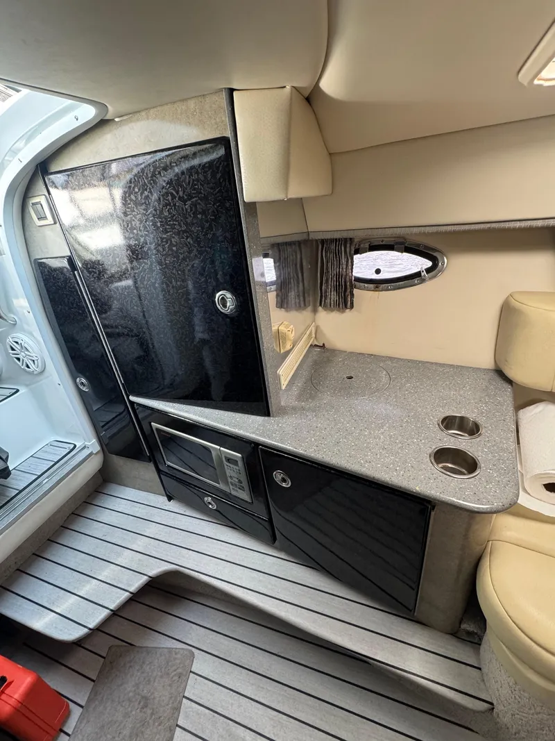 Slide: The Image of Interior of a 2007 Formula 330 SS boat, featuring a compact kitchenette. - 20