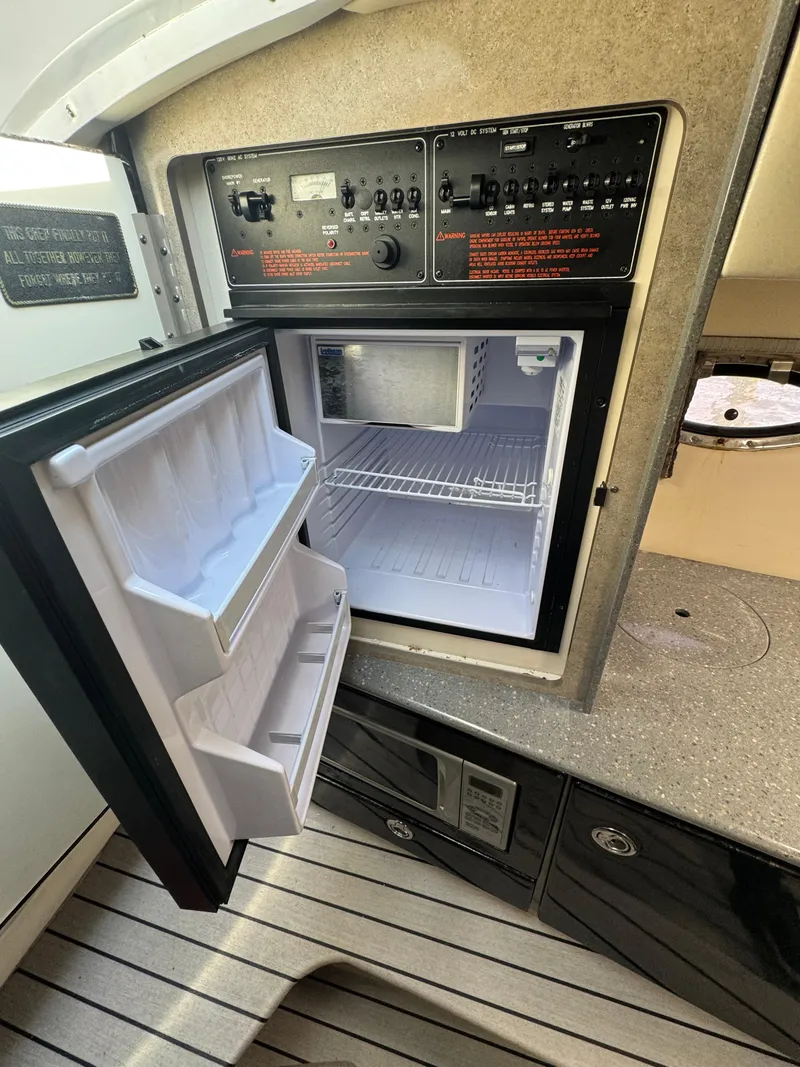 Slide: The Image of 2007 Formula 330 SS boat interior with open mini fridge and control panel. - 22