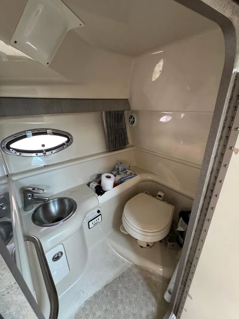 Slide: The Image of 2007 Formula 330 SS boat bathroom with sink, toilet, and porthole window. - 25