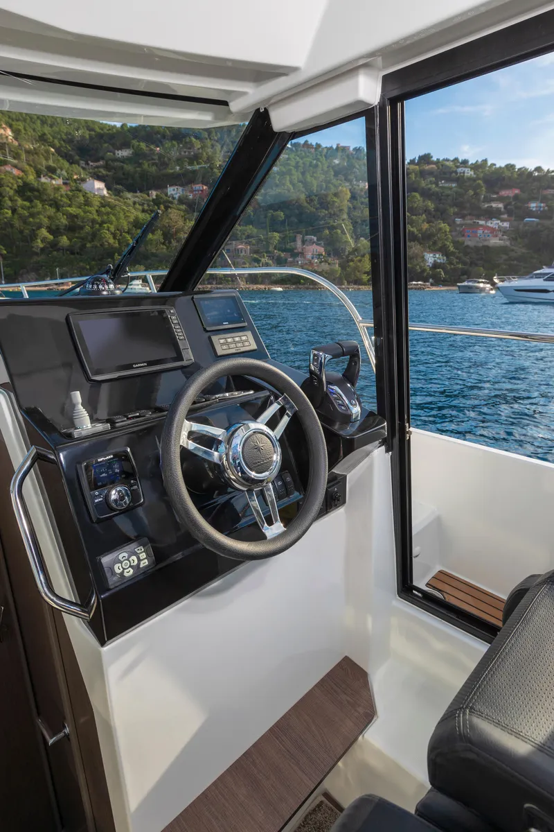 Slide: The Image of 2025 Jeanneau NC895 S2 helm with scenic ocean view and modern controls. - 9