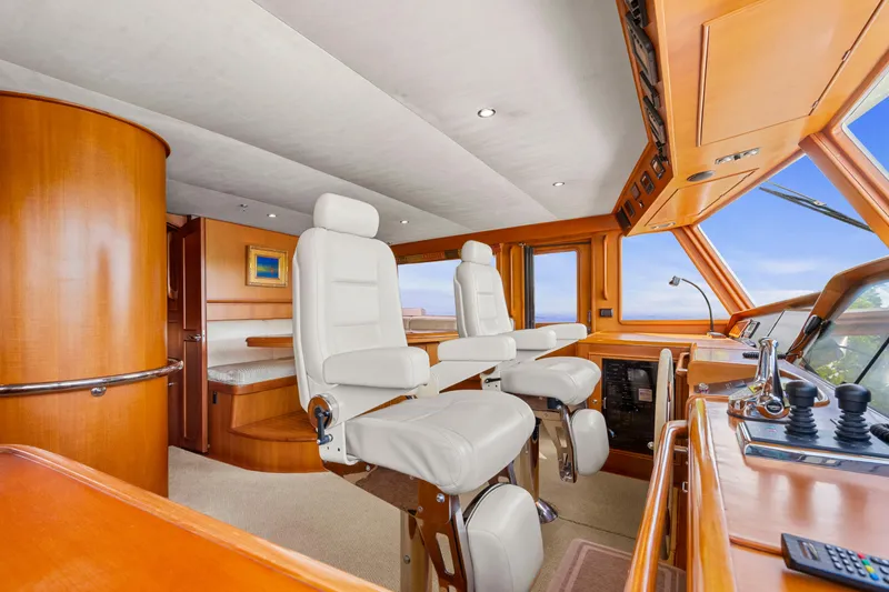 Slide: The Image of Luxurious 2006 Fleming 75 yacht interior with plush white captain chairs and wooden accents. - 15