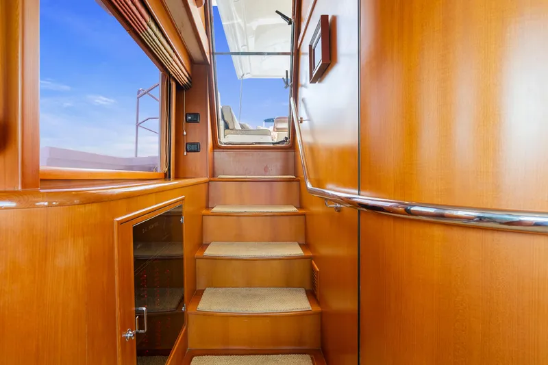 Slide: The Image of Staircase inside 2006 Fleming 75 yacht with wooden finish and carpeted steps. - 22