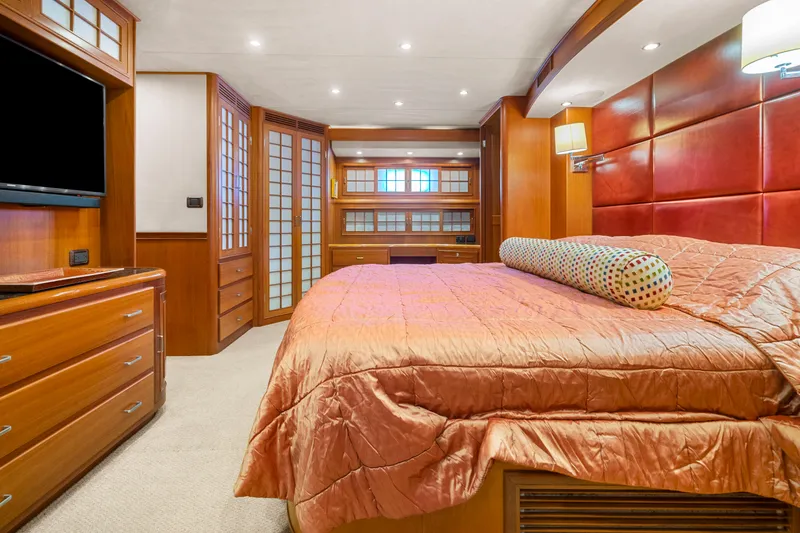 Slide: The Image of Luxurious bedroom interior in a 2006 Fleming 75 yacht, featuring elegant wood finishes and modern amenities. - 26