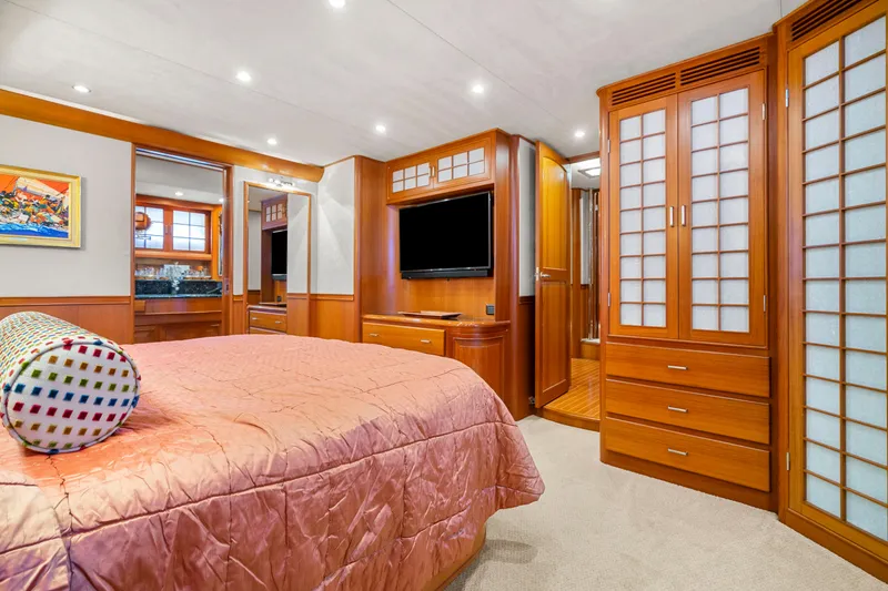Slide: The Image of Luxurious bedroom interior on 2006 Fleming 75 yacht with wood paneling and modern amenities. - 27