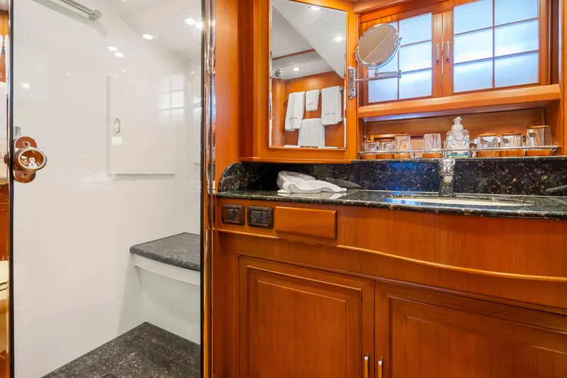 Slide: The Image of Luxurious bathroom interior on a 2006 Fleming 75 yacht, featuring wood cabinetry and granite countertops. - 29