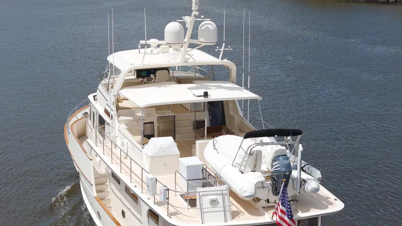 Slide: The Image of Luxury Fleming 75 yacht from 2006 on calm water, featuring spacious deck and equipment. - 47