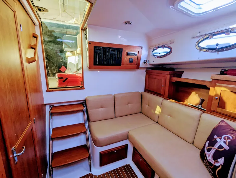 Slide: The Image of 2014 Back Cove 34 interior with beige seating, wooden accents, and nautical decor. - 14