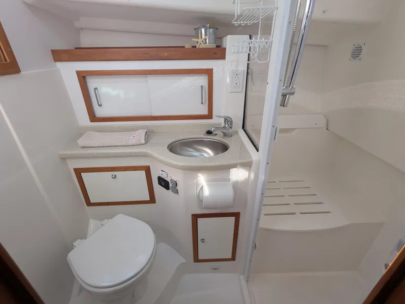 Slide: The Image of 2014 Back Cove 34 yacht bathroom with sink, toilet, and shower area. - 19