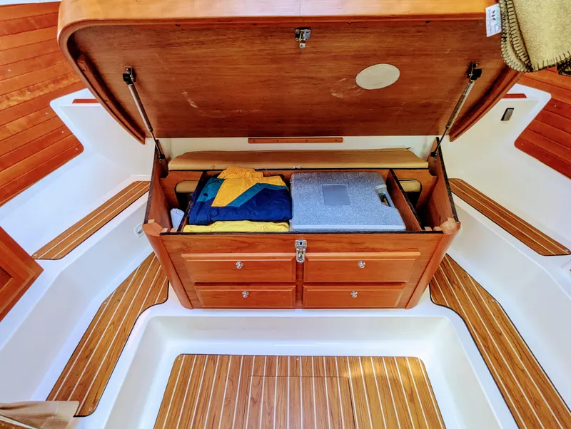 Slide: The Image of 2014 Back Cove 34 boat interior with open wooden storage compartment and neatly arranged items. - 22