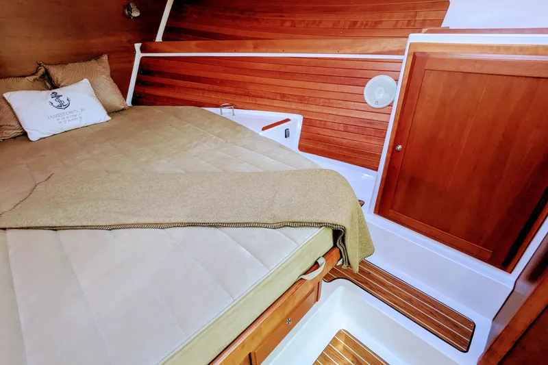 Slide: The Image of 2014 Back Cove 34 cabin interior with wooden paneling and cozy bed. - 23