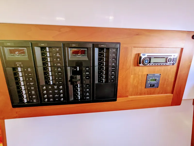 Slide: The Image of Electrical control panel on a 2014 Back Cove 34 boat, featuring switches and a stereo system. - 24