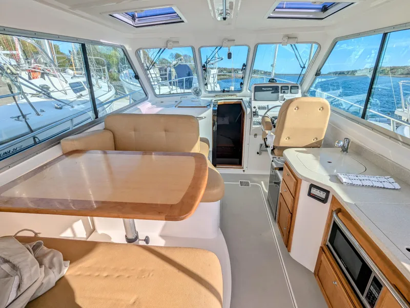 Slide: The Image of 2014 Back Cove 34 yacht interior with seating, table, and helm, showcasing luxury and comfort. - 4