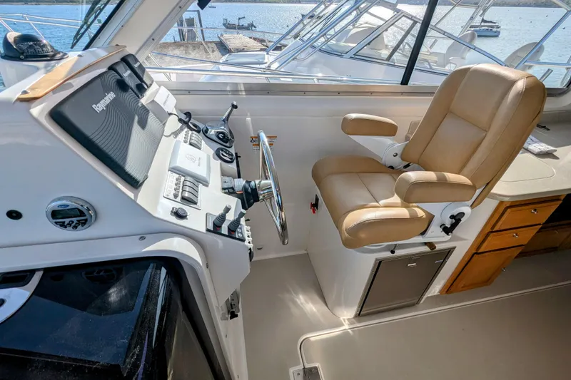 Slide: The Image of Helm of 2014 Back Cove 34 boat with tan captain's chair and navigation controls. - 5