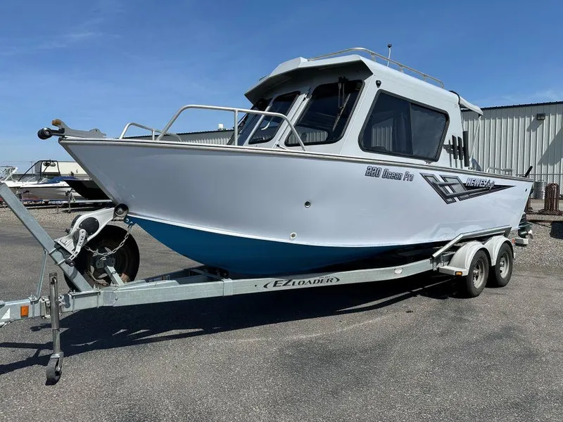 Slide: The Image of 2016 Hewescraft 220 Ocean Pro HT BH boat on trailer, parked outdoors. - 0