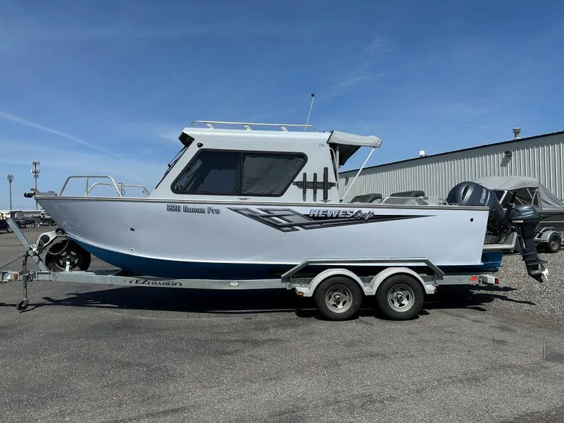 Slide: The Image of 2016 Hewescraft 220 Ocean Pro HT BH boat on trailer, parked outdoors. - 1