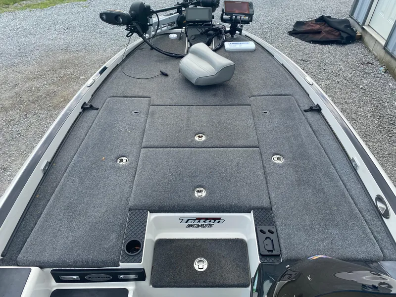 Slide: The Image of 2011 Triton 21 HP SC boat deck with storage compartments and fishing equipment. - 13