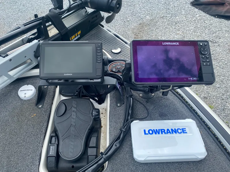 Slide: The Image of Fishing boat dashboard with Garmin and Lowrance displays, foot pedal, and Lowrance storage box. Triton 21 HP SC, 2011. - 14