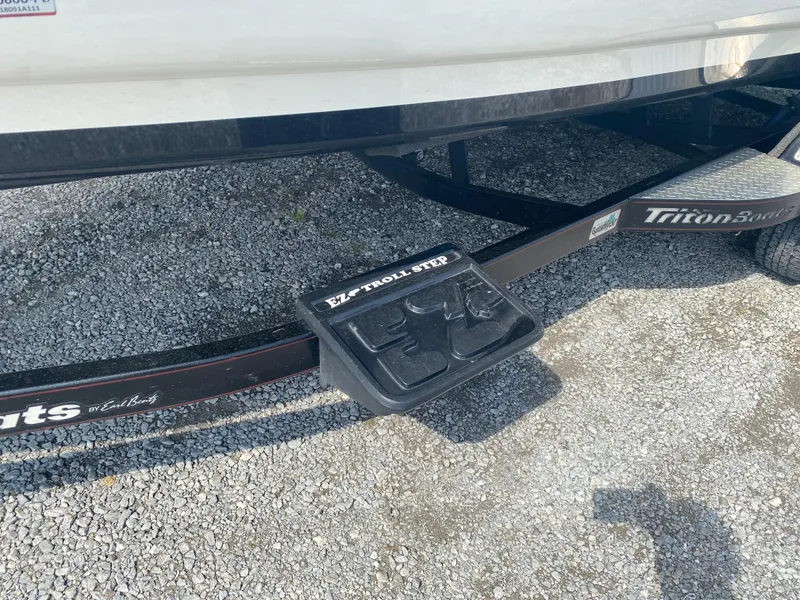 Slide: The Image of Triton 21 HP SC 2011 boat trailer with EZ Troll Step on gravel. - 6