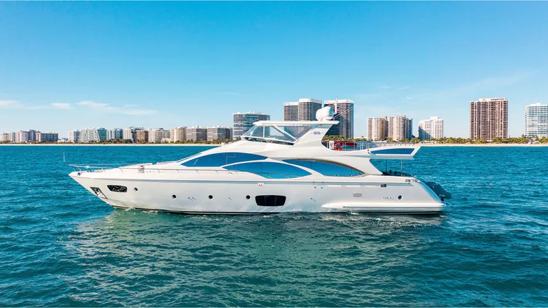 Slide: The Image of Azimut 95 yacht cruising on blue water with city skyline in the background, 2010 model. - 0