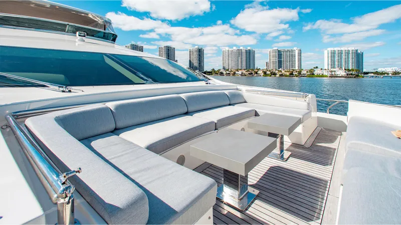 Slide: The Image of Luxurious 2010 Azimut 95 yacht deck with seating, tables, and waterfront cityscape. - 11