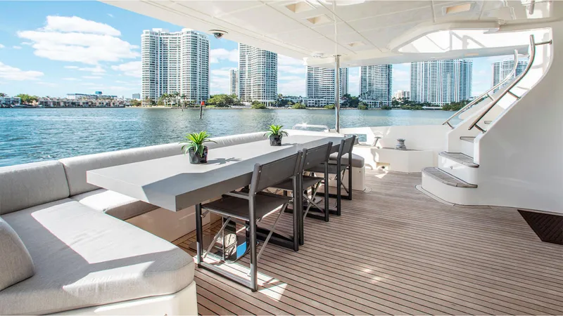 Slide: The Image of Luxurious Azimut 95 yacht deck with dining area, modern seating, and waterfront cityscape view. - 3