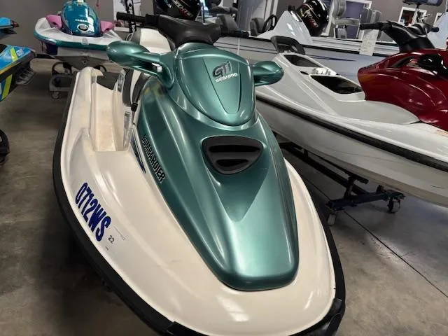 Slide: The Image of 2000 Sea-Doo GTI jet ski in showroom, green and white design, side view. - 3