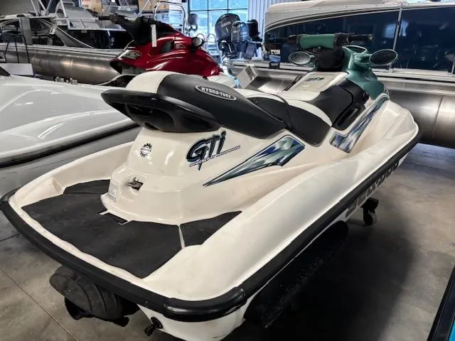 Slide: The Image of 2000 Sea-Doo GTI jet ski in showroom, white and teal design. - 6