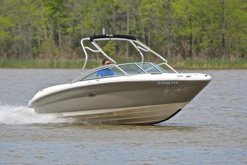 Slide: The Image of 2005 Sea Ray 220 Select boat cruising on a lake with lush green trees in the background. - 1