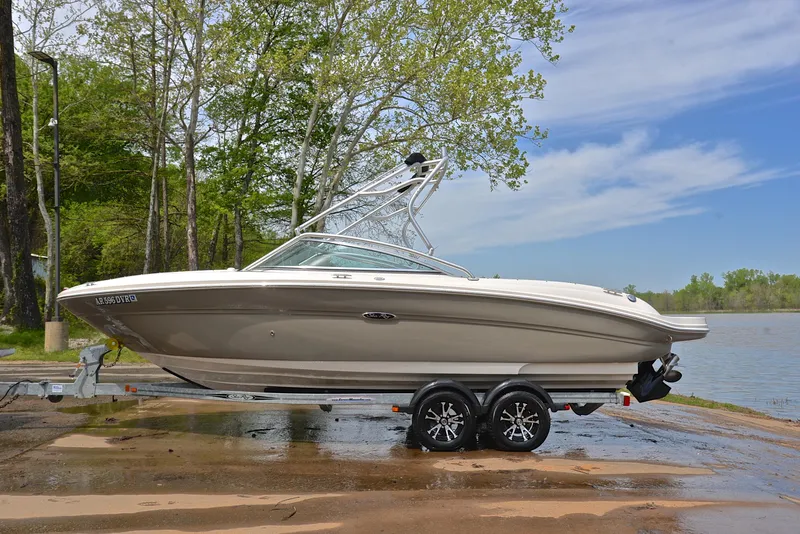 Slide: The Image of 2005 Sea Ray 220 Select boat on trailer by a lake, surrounded by trees. - 10
